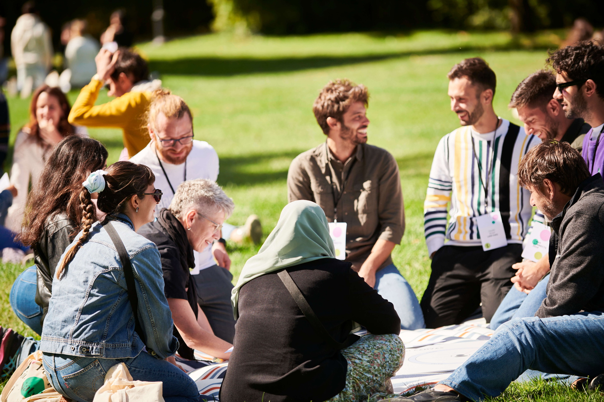 A diverse group of people sitting in a circle on a blanket, team-building activities