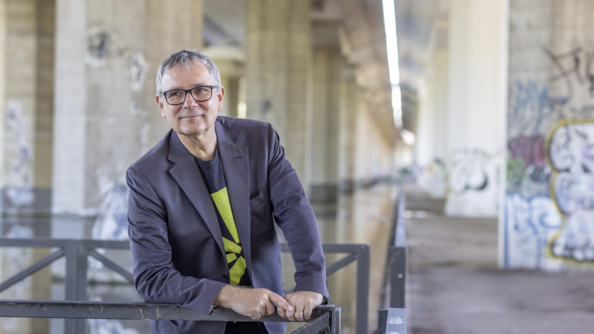 A man standing in pose under a bridge