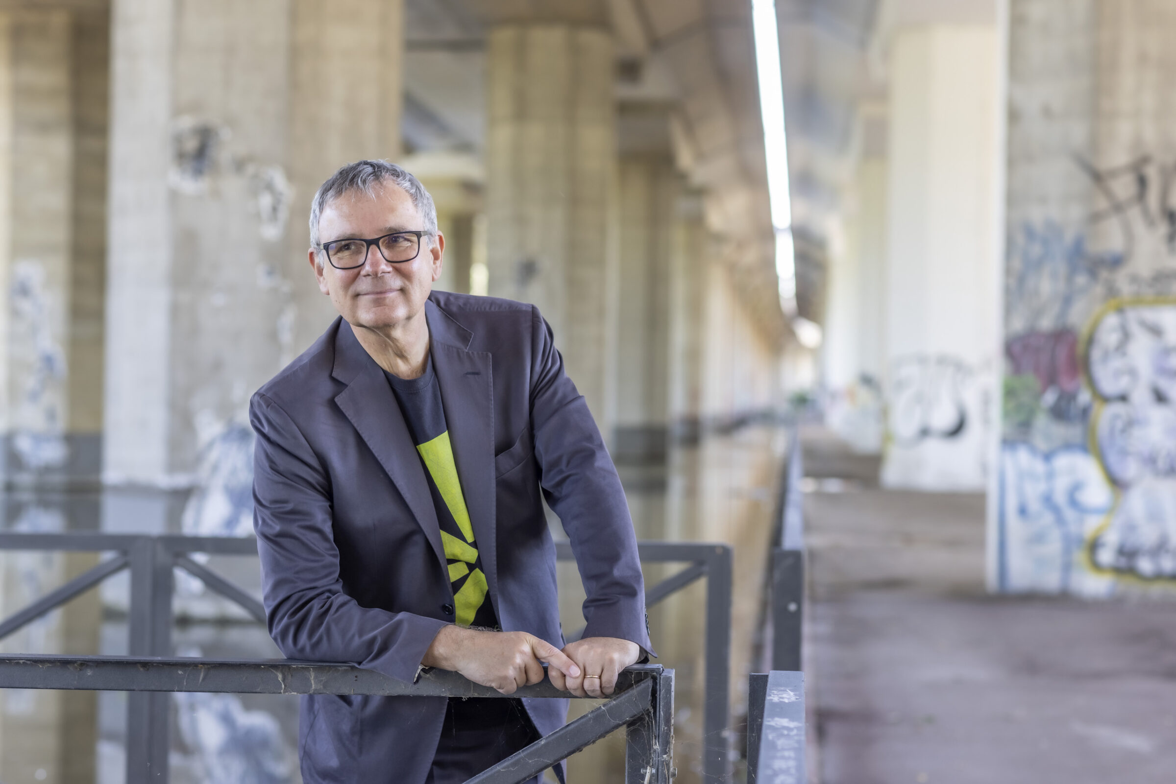 A man standing in pose under a bridge