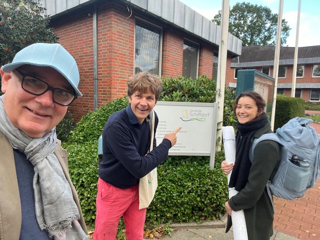 A man, a young man and a woman in front of a building